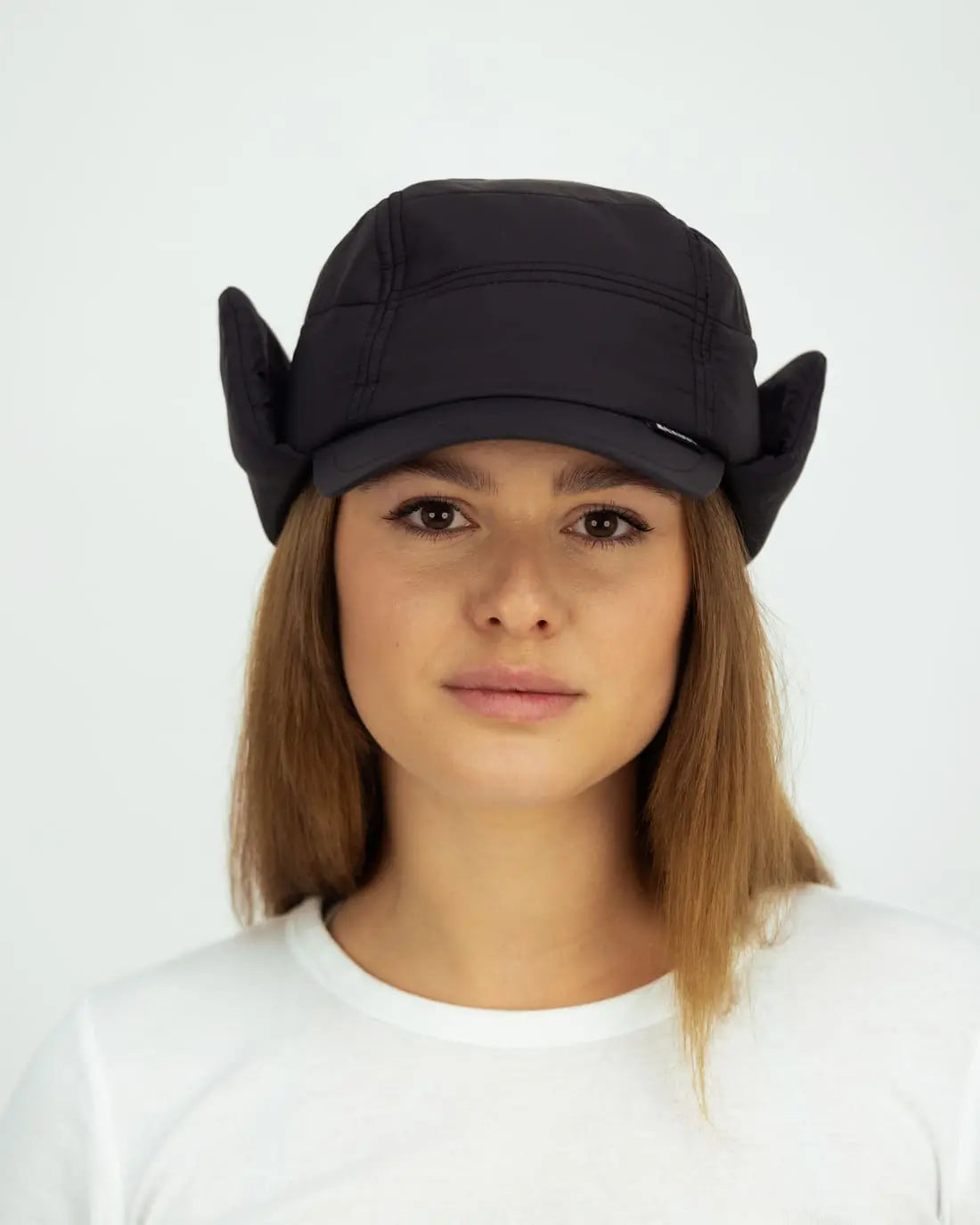 Front view of the KUGY Insulated Mountain Cap in a studio setting, highlighting the cap’s design and ear covers